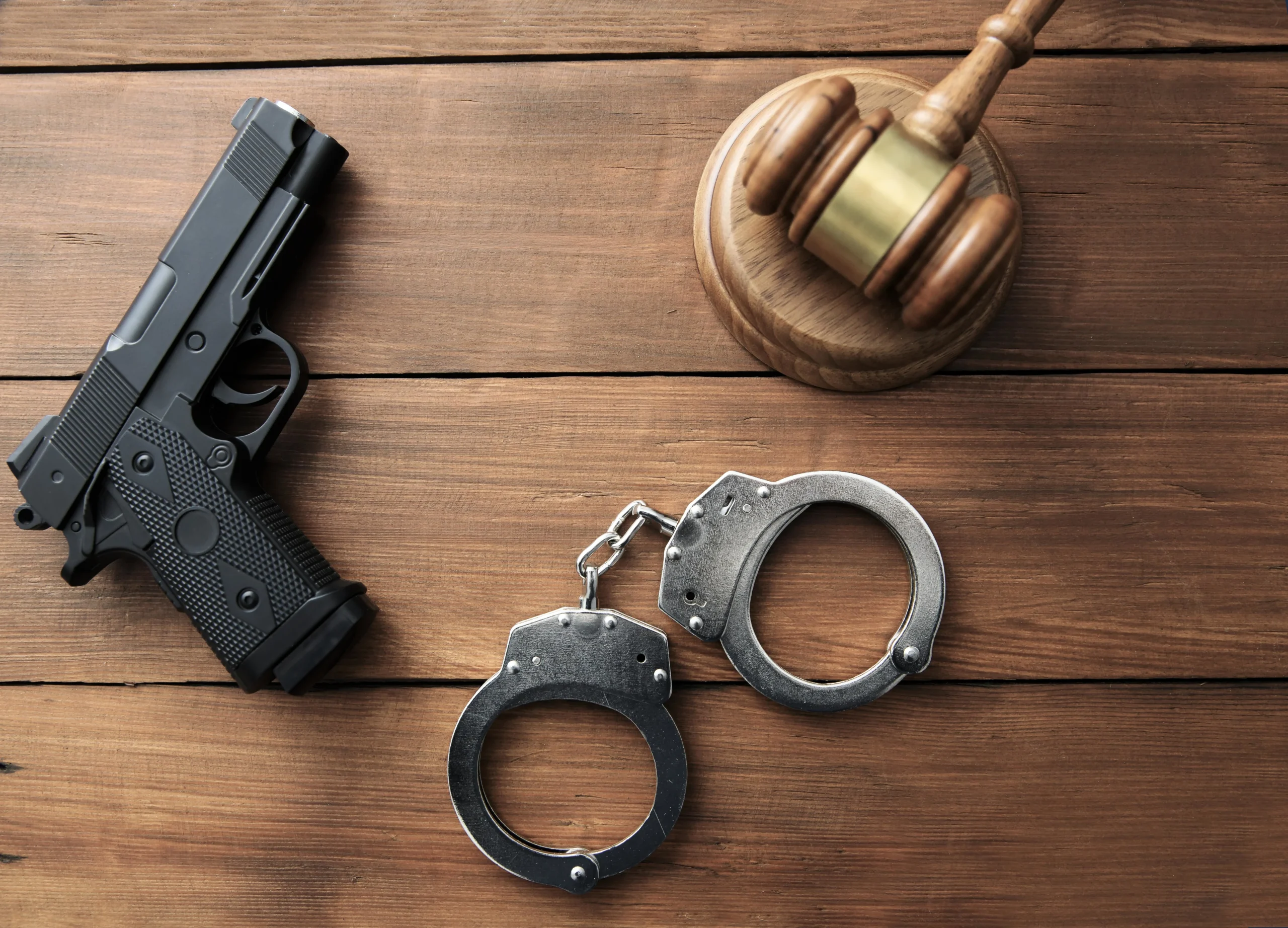 Gun with hammer next to justice gavel. If you’ve been convicted of a serious crime and in need of an aggressive Fort Bend County criminal defense lawyer, contact us now.