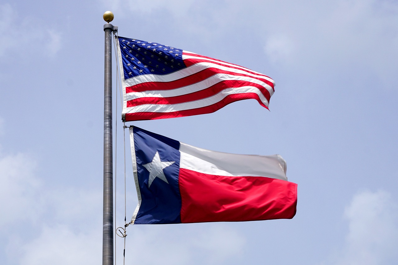Texas flag and American flag on a flag pole.